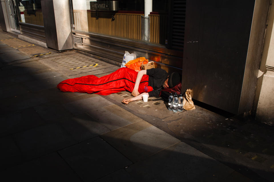 A homeless man sleeps on Cranbourn Street in London, England, on June 23, 2020. British Prime Minister Boris Johnson announced today that the next stage of lockdown easing in England would proceed on schedule, with pubs, restaurants, hotels, hairdressers, theatres, cinemas, museums, galleries, libraries, theme parks and zoos allowed to reopen from July 4. The two-metre social distancing rule is also to be halved from the same date, with people encouraged to take additional mitigation actions, such as wearing face coverings, when close together. The change, to what is being dubbed 'one-metre plus', is seen as key to the survival of the hospitality sector. (Photo by David Cliff/NurPhoto via Getty Images)