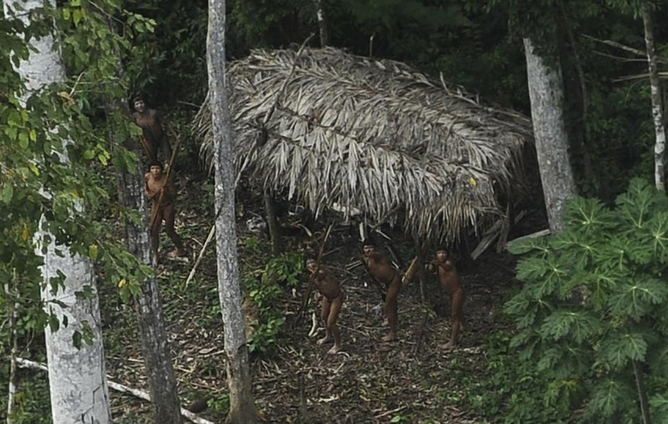 Uncontacted Indians react to a plane flying over their community in the Amazon basin