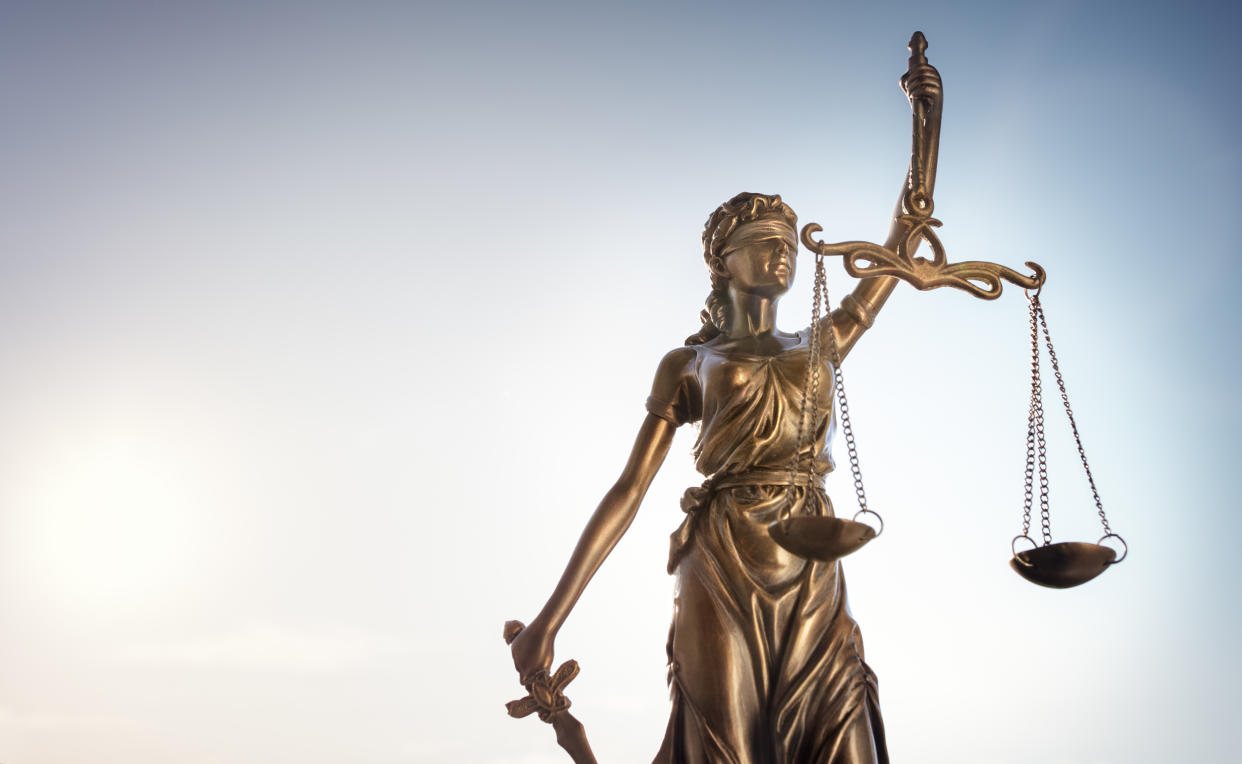 Legal and law concept statue of Lady Justice with scales of justice and sky background