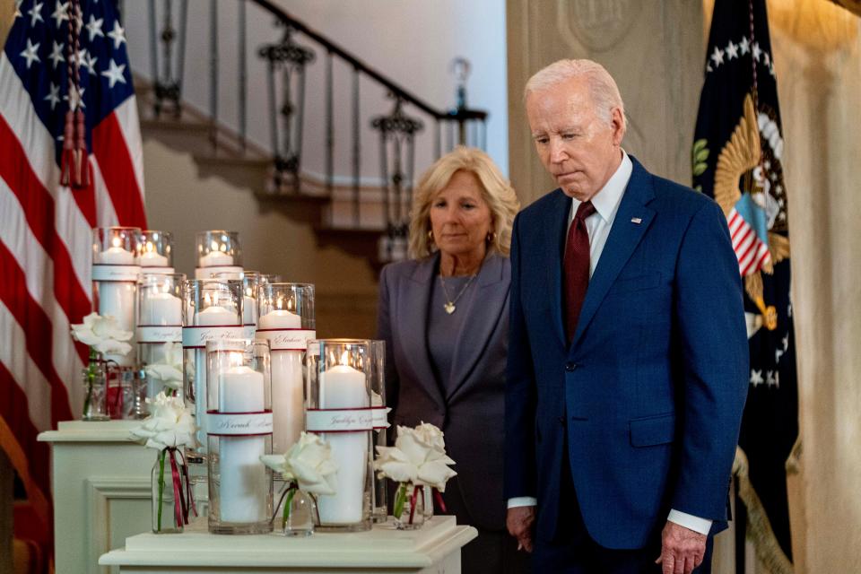 President Joe Biden, accompanied by first lady Jill Biden, looks at flowers and candles with the names of victims as he arrives to speak on the one year anniversary of the school shooting in Uvalde, Texas, at the White House in Washington, Wednesday, May 24, 2023.