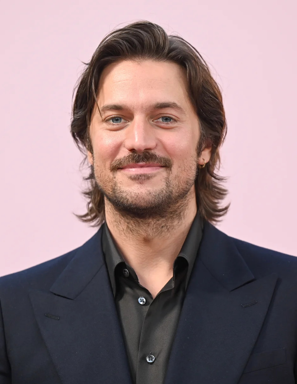 Lucas Bravo in a suit at the premiere of "Emily in Paris"