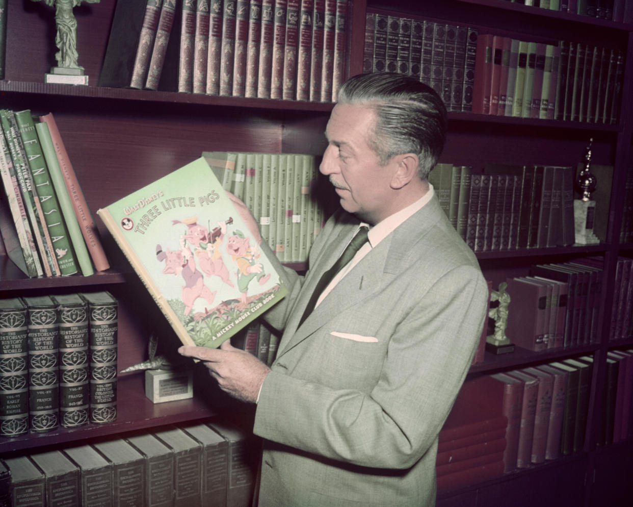 American film producer Walt Disney (1901 - 1966) holding a Mickey Mouse Club edition of the 'Three Little Pigs' story, circa 1955.  (Photo by Silver Screen Collection/Getty Images)