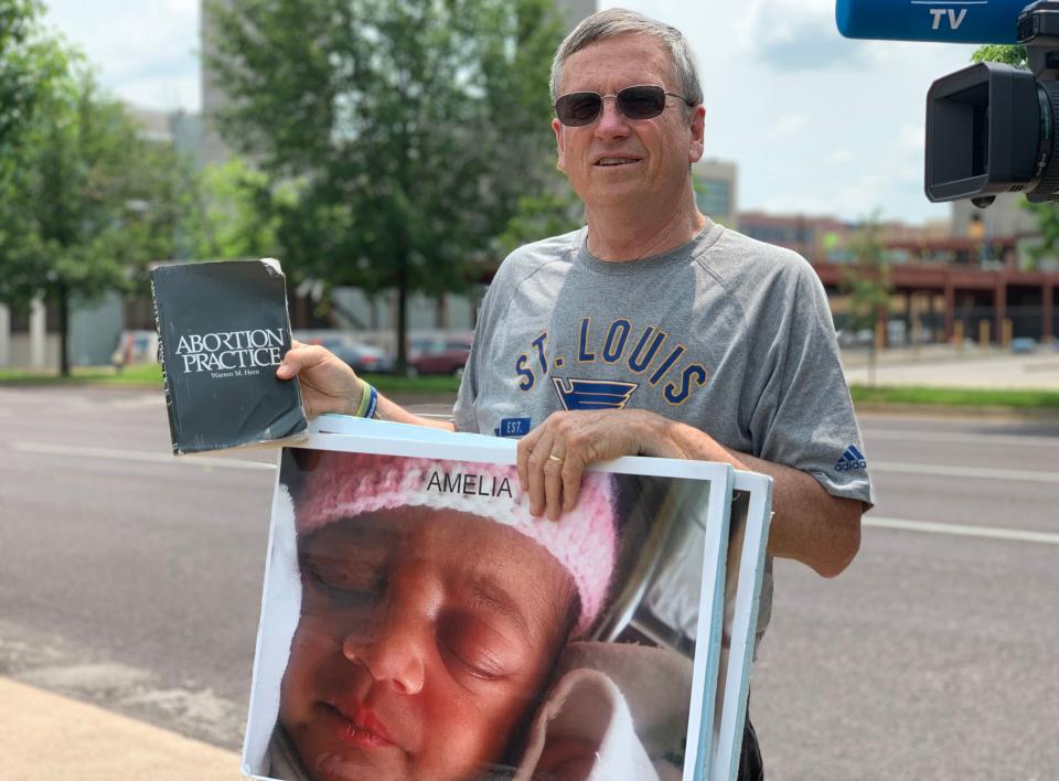 John Ryan, an anti-abortion protester, reads the "Abortion Practice" book out loud to people to dissuade them from going into the St. Louis clinic.&nbsp; (Photo: Melissa Jeltsen, HuffPost)