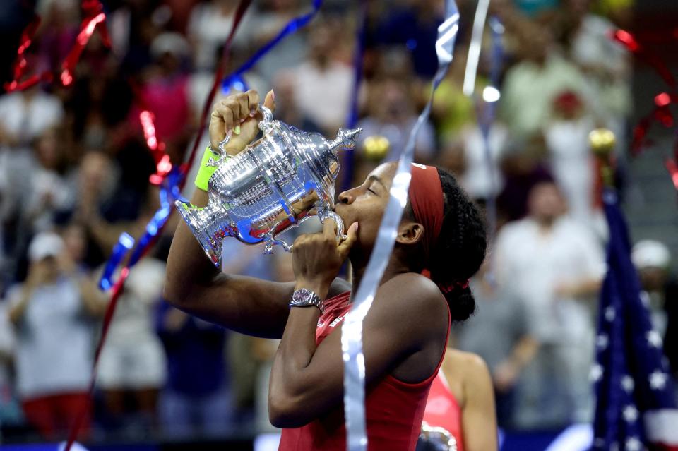 Coco Gauff kisses her 2023 US Open trophy.