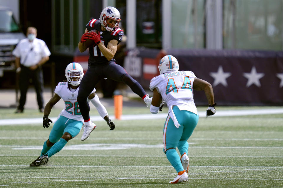 New England Patriots wide receiver Julian Edelman (11) attempts to catch a pass between Miami Dolphins safety Bobby McCain (28) and linebacker Elandon Roberts (44) in the first half of an NFL football game, Sunday, Sept. 13, 2020, in Foxborough, Mass. (AP Photo/Charles Krupa)