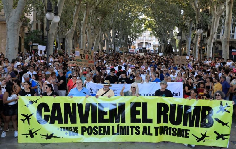 People participate in a demonstration called by the organization "Less Tourism, More Life" against mass tourism in Mallorca.  Clara Margais/dpa