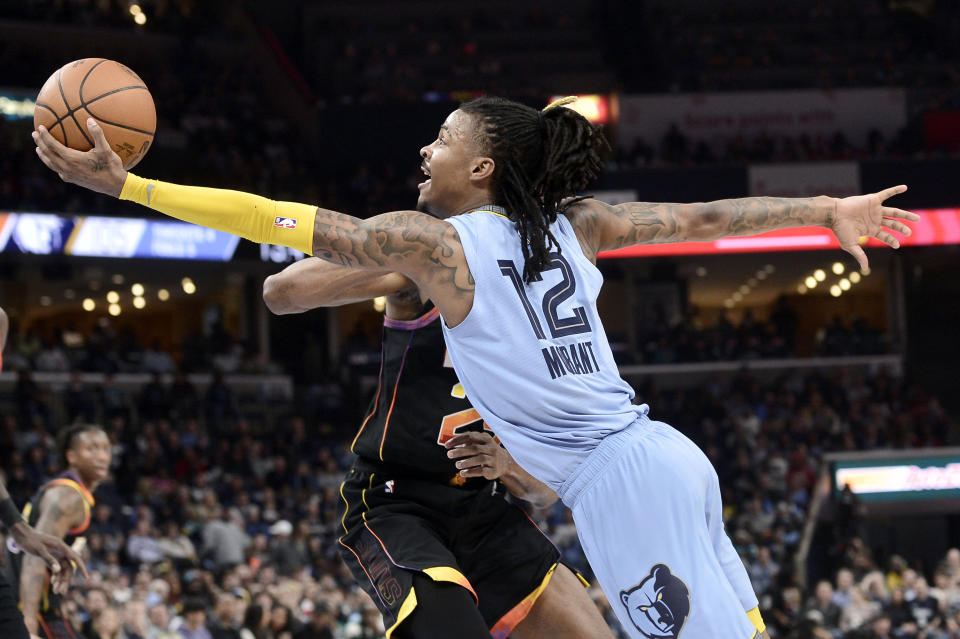 Memphis Grizzlies guard Ja Morant (12) shoots against Phoenix Suns forward Mikal Bridges in the second half of an NBA basketball game Monday, Jan. 16, 2023, in Memphis, Tenn. (AP Photo/Brandon Dill)