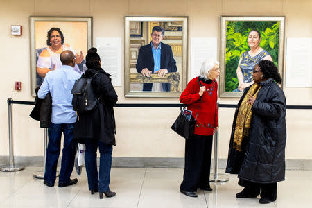 Visitors examine Artist Betsy Ashton's exhibition, "Portraits of Immigrants: Unknown Faces, Untold Stories" at Riverside Church in New York, U.S., March 10, 2019. REUTERS/Demetrius Freeman