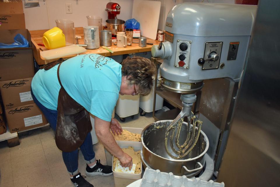 Melody Lauritson moves cookie dough from the 60-quart mixer at Cookies, etc. at North Grand Mall in Ames.