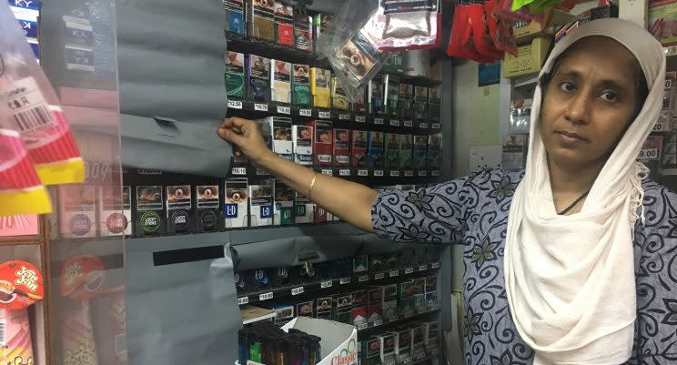 Mr Shehabudn’s wife showing how her mama shop will be covering up tobacco products. (Photo: Gabriel Choo/ Yahoo News Singapore)