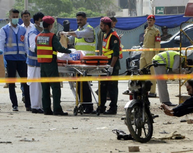 Pakistani security officials collect evidence from the scene of an attack on a census team in Lahore