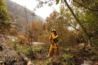 A firefighter from El Dorado Hills pauses in rugged terrain while creating fire breaks at Garrapata State Park during the Soberanes Fire north of Big Sur, California, U.S. July 31, 2016. REUTERS/Michael Fiala