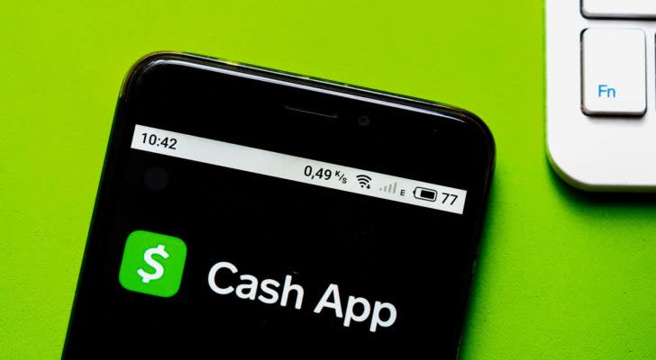 The Cash App (SQ) logo is displayed on an iPhone screen.