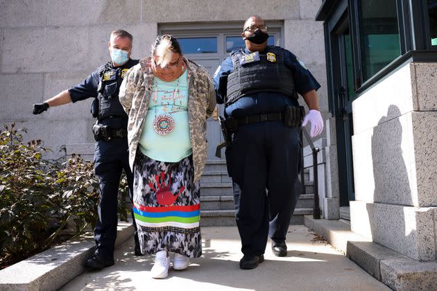 Police officers escort a protester out of the Department of Interior building after a sit-in held by climate activists on Oct. 14 in Washington, D.C. (Photo: Kevin Dietsch via Getty Images)