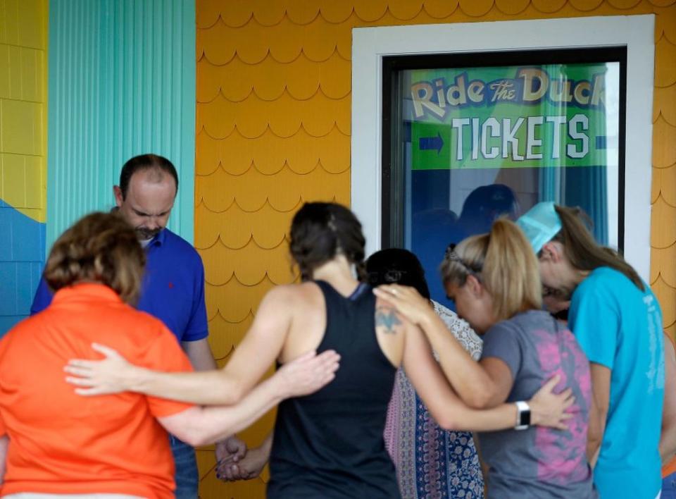 People pray outside Ride the Ducks