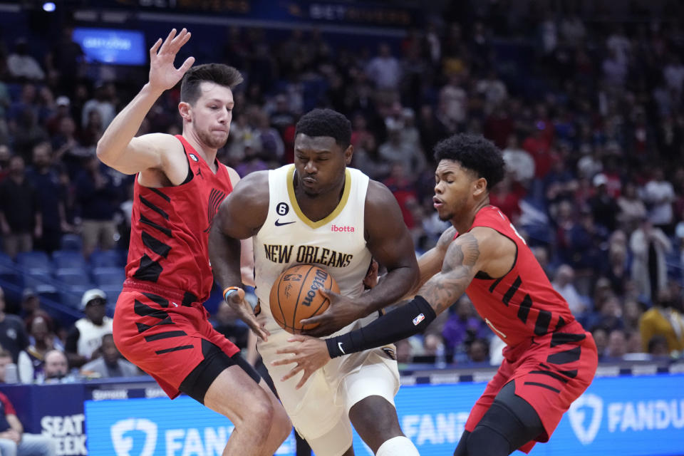 New Orleans Pelicans forward Zion Williamson (1) drives to the basket between Portland Trail Blazers forward Drew Eubanks, left, and guard Anfernee Simons (1) during the first half of an NBA basketball game in New Orleans, Thursday, Nov. 10, 2022. (AP Photo/Gerald Herbert)