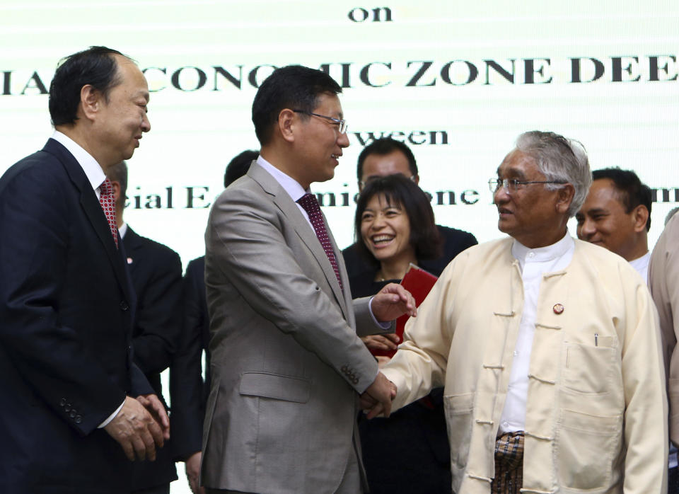 FILE - In this Nov. 8, 2018, file photo, Myanmar Commerce Minister Dr Than Myint, right, shakes hands with Chinese Ambassador to Myanmar Hong Liang, center, and Chairman of CITIC Construction Chang Zhenming, left, after the Signing Ceremony of the Framework Agreement Kyauk Phyu Special Economic Zone Deep Sea Port Project between Kyauk Phyu Special Economic Zone Management Committee and CITIC Consortium in Naypyitaw, Myanmar. The military coup in Myanmar on Monday, Feb. 1, 2021 reflects the leadership's return to leaning on support from Beijing after the international condemnation of the country's treatment of its Rohingya minority. (AP Photo/Aung Shine Oo)