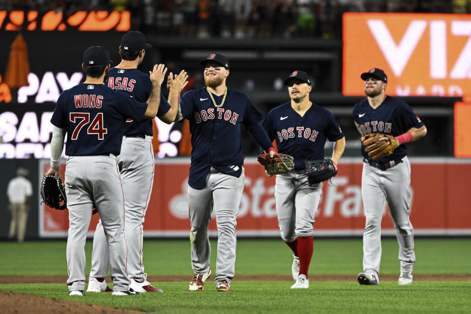 Boston Red Sox players greet each other after defeating the Baltimore Orioles 17-4 in a baseball game, Saturday, Sept. 10, 2022, in Baltimore. (AP Photo/Terrance Williams)