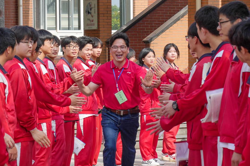 Examinees high five with their teacher outside an exam venue of the 2023 National College Entrance Exam (aka Gaokao) on June 7, 2023 in Huzhou.