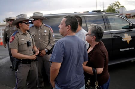 A couple look on after a mass shooting at a Walmart in El Paso