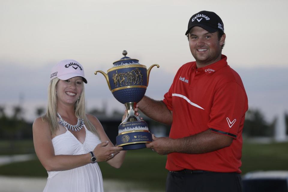 Patrick Reed and his wife Justice hold The Gene Sarazen Cup after winning the Cadillac Championship golf tournament Sunday, March 9, 2014, in Doral, Fla. (AP Photo/Wilfredo Lee)