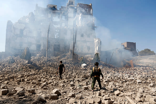 Huthi rebel fighters inspect the damage after a reported air strike carried out by the Saudi-led coalition targeted the presidential palace in the Yemeni capital Sanaa in December 2017. Source: Getty
