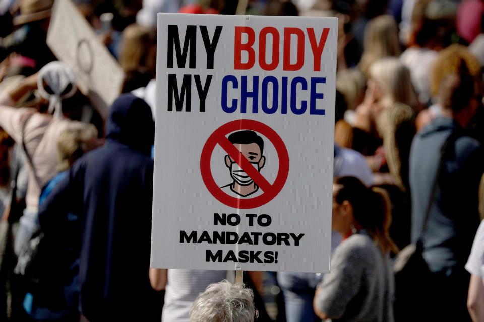 Protesters held banners calling the pandemic a 'hoax' and demanding an end to mandatory face masks (AP)