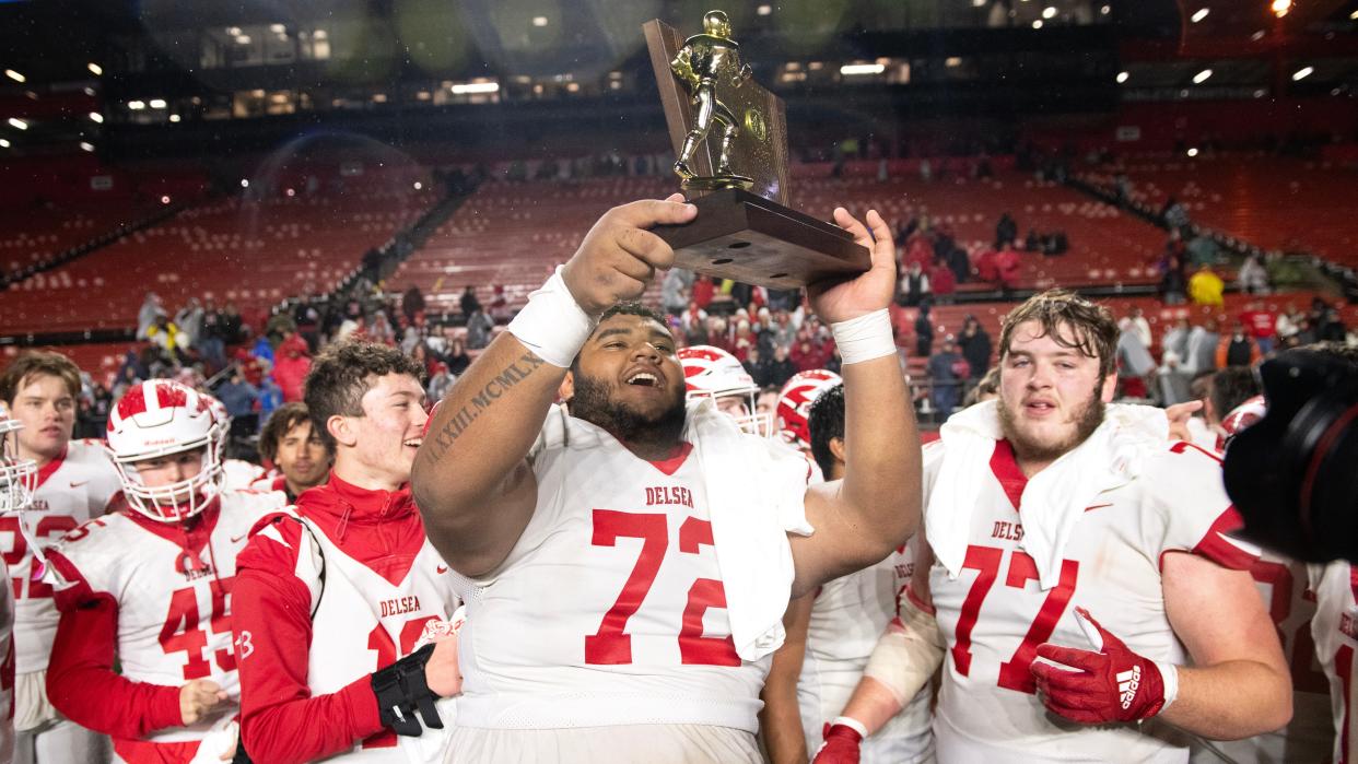 Delsea's Greg Masso hoists the trophy and celebrates with teammates after Delsea defeated West Essex, 28-3, in the Group 3 state championship football game played at Rutgers University in Piscataway on Sunday, November 26, 2023.