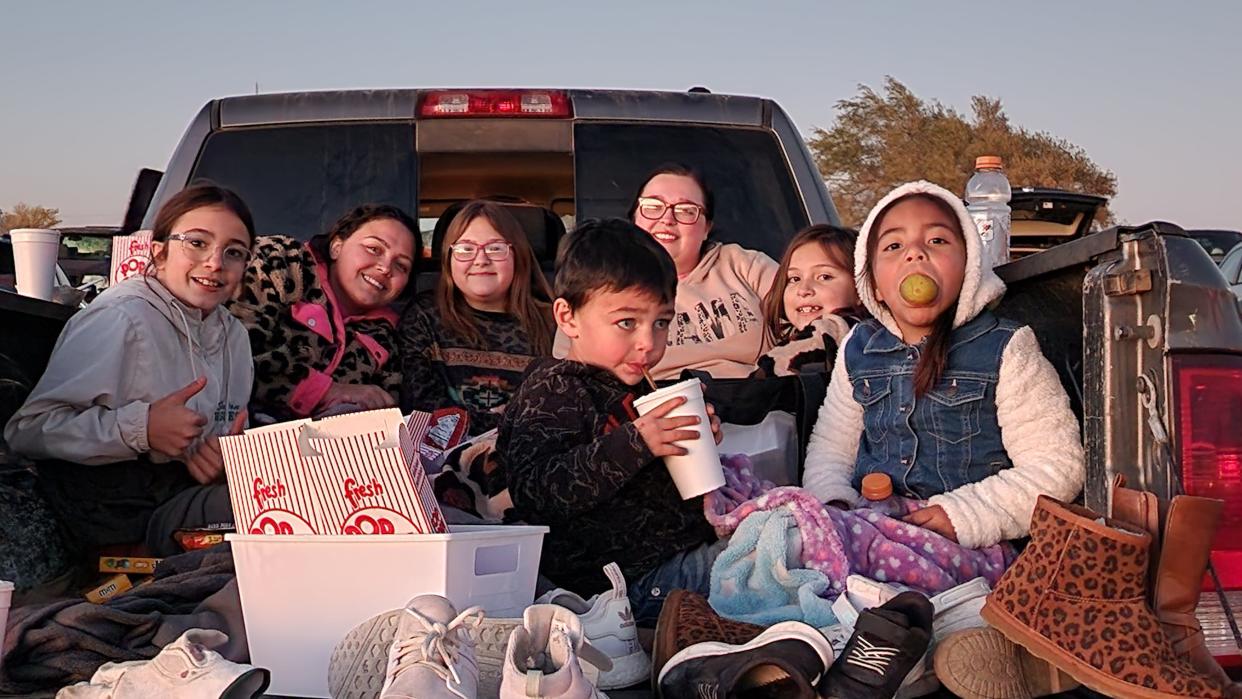 A family gathers for the final showing of the Tascosa Drive-in Friday night in Amarillo.