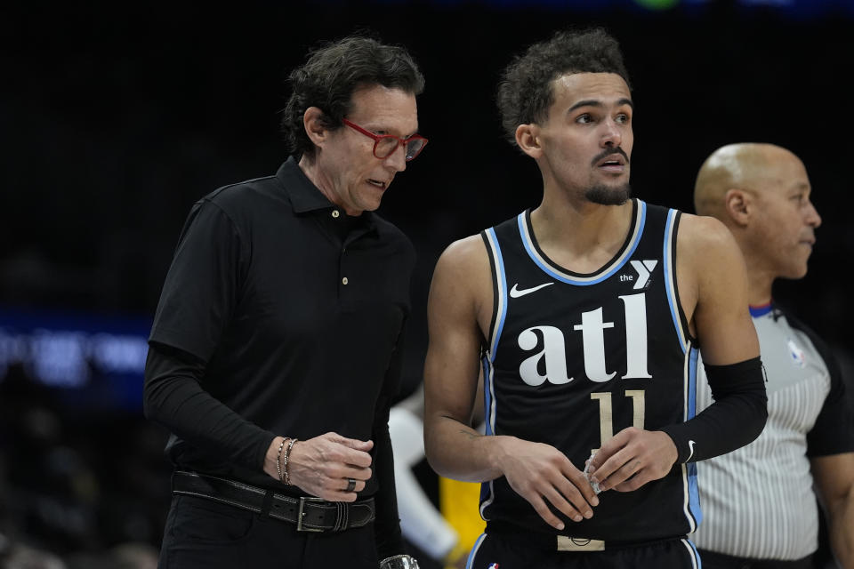 Atlanta Hawks head coach Quin Snyder talks with guuard Trae Young in the second half of an NBA basketball game against the Los Angeles Lakers Tuesday, Jan. 30, 2024, in Atlanta. (AP Photo/John Bazemore)