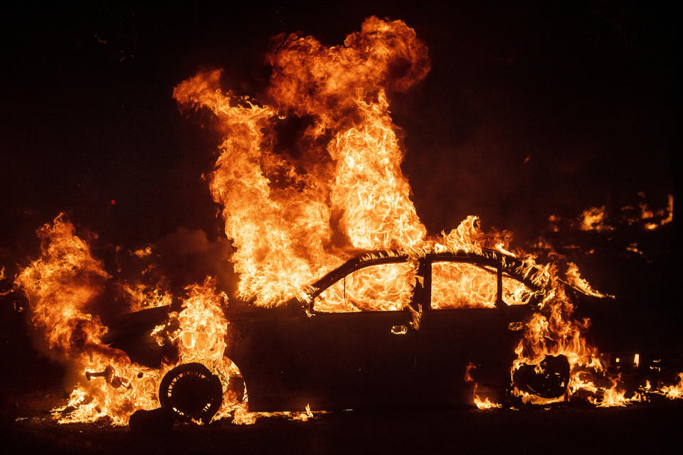 Flames from the Kincade Fire consume a car in the Jimtown community of unincorporated Sonoma County, Calif., on Thursday, Oct. 24, 2019. Wildfires are growing deadlier and more destructive amid climate change. (AP Photo/Noah Berger)