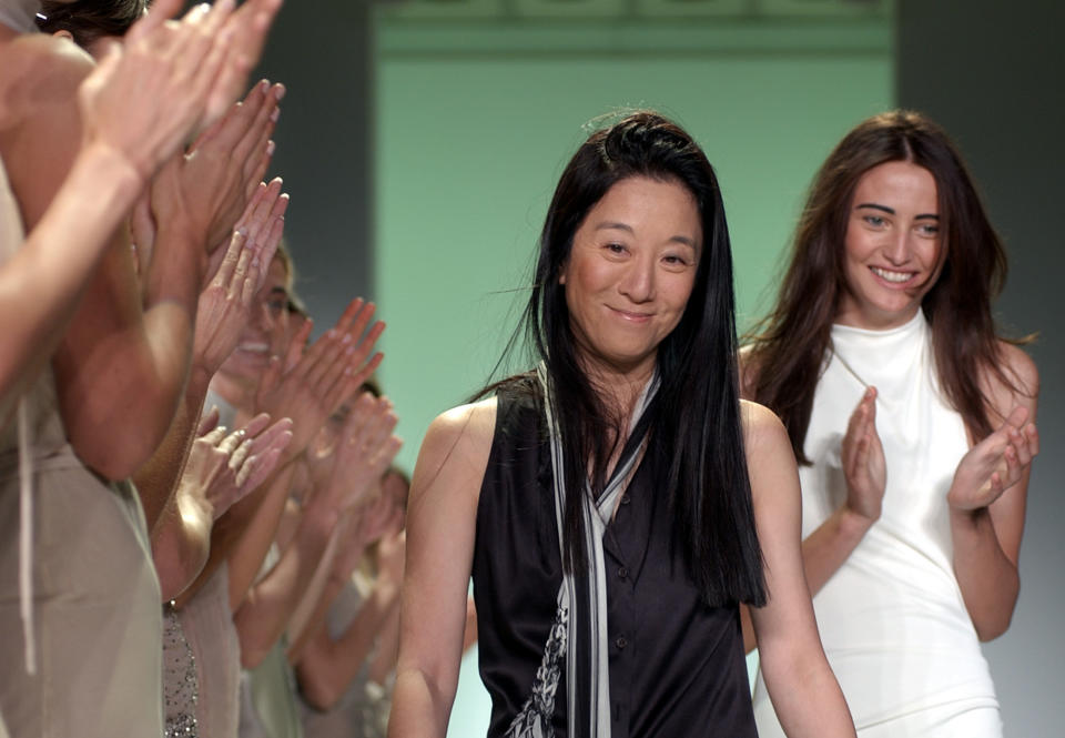 FILE- This Sept. 20, 2002 file photo shows designer Vera Wang, center, as she is applauded by her models and the audience following the presentation of her spring-summer 2003 collection in New York. Wang, 63, was honored for her lifetime achievement by the Council of Fashion Designers at its star-studded awards show Monday night. She received the award from her former employer and mentor Ralph Lauren, and she received a standing ovation from her peers. (AP Photo/Richard Drew, FILE)