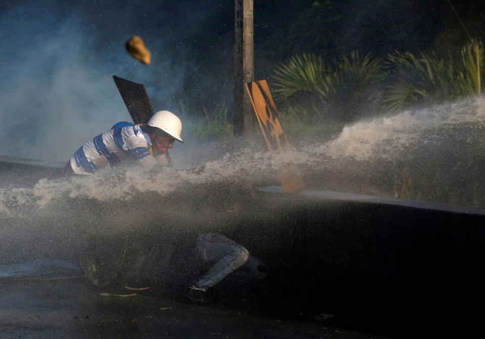 <p>Opposition supporters clash with riot security forces while rallying against President Nicolas Maduro in Caracas, Venezuela, May 18, 2017. (Carlos Garcia Rawlins/Reuters) </p>