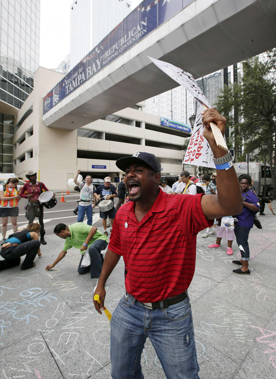 Franz Nertte, of Miami, shouts during a protest march in Tampa, Fla., Sunday, Aug. 26, 2012. Hundreds of protestors gathered in Gas Light Park in downtown Tampa to march in demonstration against the Republican National Convention. (AP Photo/Dave Martin)