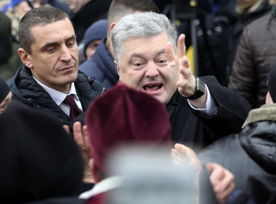Ukrainian President Petro Poroshenko, center, greets people gathered to support independent Ukrainian church near the St. Sophia Cathedral in Kiev, Ukraine, Saturday, Dec. 15, 2018. Ukraine's Orthodox clerics gather for a meeting Saturday that is expected to form a new, independent Ukrainian church, and Ukrainian authorities have ramped up pressure on priests to support the move. (AP Photo/Efrem Lukatsky)