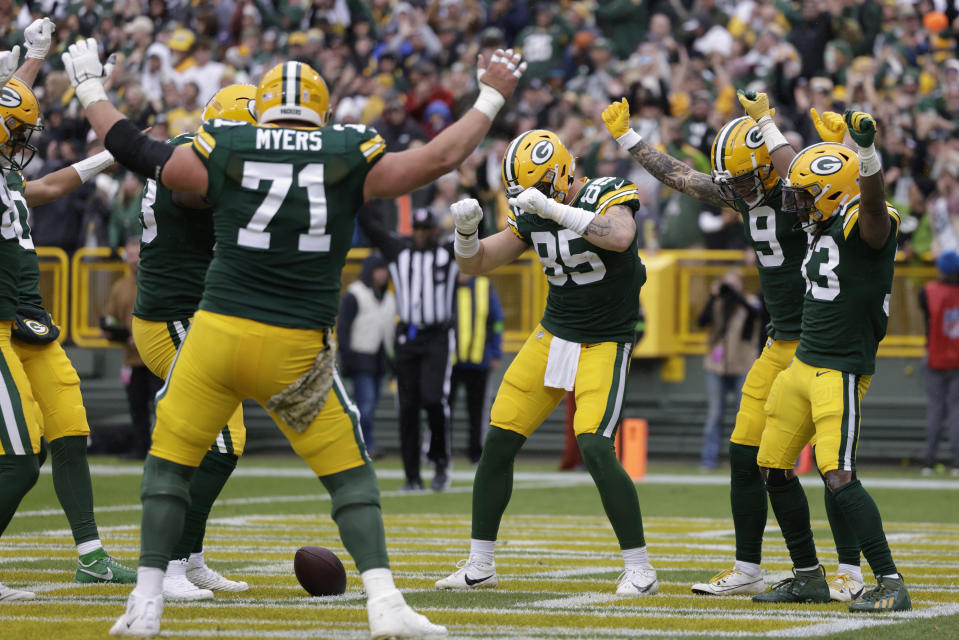 Green Bay Packers running back Aaron Jones (33), right, celebrates with teammates after scoring a 3-yard rushing touchdown during the first half of an NFL football game against the Los Angeles Rams, Sunday, Nov. 5, 2023, in Green Bay, Wis. (AP Photo/Matt Ludtke)