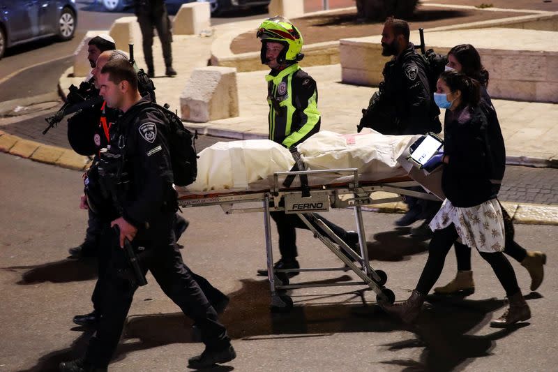 Police officers and medics evacuate a body, near Damascus Gate