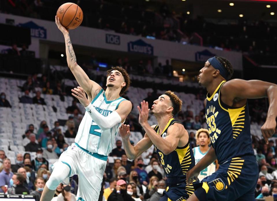 Charlotte Hornets guard LaMelo Ball, left, drives to the basket with the Indiana Pacers defense giving chase Wednesday.