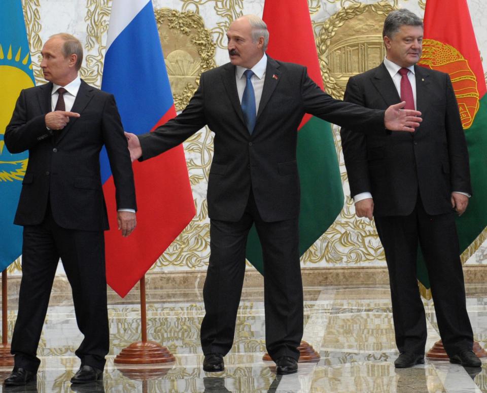 FILE - From left, Russian President Vladimir Putin, Belarusian President Alexander Lukashenko and then-Ukrainian President Petro Poroshenko meet prior to talks in Minsk, Belarus, on Tuesday, Aug. 26, 2014. The Minsk agreement brokered by France and Germany, following painful defeats suffered by Ukrainian forces, obliged Kyiv to offer the separatist regions broad autonomy, including permission to form their own police force. (Alexei Druzhinin, Sputnik, Kremlin Pool Photo via AP, File)