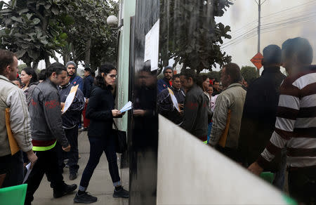 Venezuelan migrants wait at the Interpol headquarters to get paperwork needed for a temporary residency permit, in Lima, Peru, August 16, 2018. REUTERS/Mariana Bazo