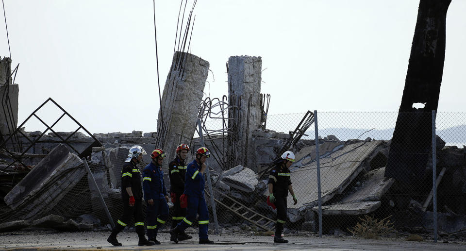 Firefighters search for trapped people at a damaged structure following an earthquake at the port of Piraeus, near Athens, Friday. Source: AP