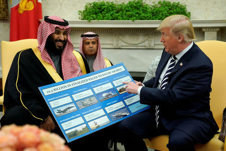 U.S. President Donald Trump holds a chart of military hardware sales as he welcomes Saudi Arabia's Crown Prince Mohammed bin Salman in the Oval Office at the White House in Washington, U.S., March 20, 2018. REUTERS/Jonathan Ernst