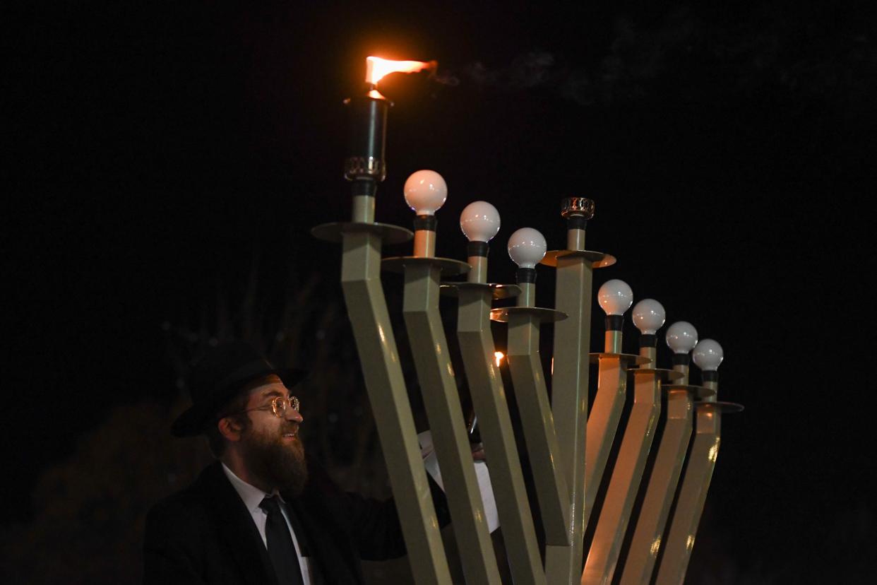 Head Rabbi Zalman Fischer lights the menorah during the Chabad of Augusta's annual Chanukah ceremony and Grand Menorah Lighting in Evans Towne Center Park on Thursday, Dec. 7, 2023.