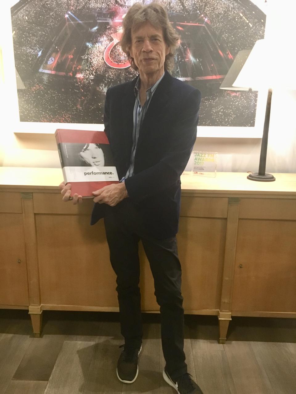 Mick Jagger holding a copy of Glennie's book