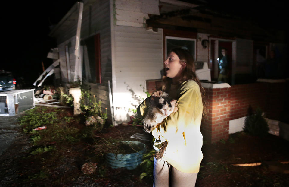 "I found Elsa," yells Gracie Burchard as she helps friends gather belongings from their destroyed rental homes in Fredericktown, Mo. on Monday, Oct. 25, 2021 after a tornado roared through the town Sunday night. (Robert Cohen/St. Louis Post-Dispatch via AP)