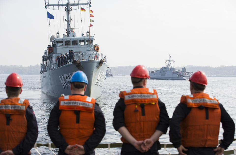 Crew members of Norwegian support vessel Valkyrien stand on board as they set sail together with Belgian minehunter Belis, left, Norwegian minesweeper Otra, right, and two other ships of the Netherlands and Estonia from Kiel, Germany, Tuesday, April 22, 2014. The warships are part of the standing NATO Mine Counter-Measures Group ONE, one of NATO’s four standing Maritime Forces, deploying to the Baltic Sea to enhance maritime security and readiness in the region. The maritime Group was reactivated by a North Atlantic Council decision to enhance collective defense and assurance measures in response to the crisis in Ukraine. (AP Photo/Gero Breloer)