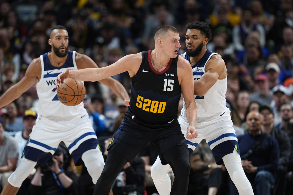 Denver Nuggets center Nikola Jokic, center, is defended by Minnesota Timberwolves center Rudy Gobert, left, and center Karl-Anthony Towns during the second half of Game 5 of an NBA basketball second-round playoff series Tuesday, May 14, 2024, in Denver (AP Photo/David Zalubowski)