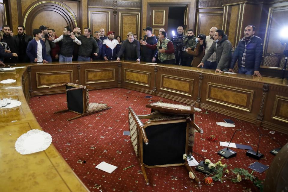 People protest against an agreement to halt fighting over the Nagorno-Karabakh region, inside the government building in Yerevan, Armenia Tuesday, Nov. 10, 2020. Armenia and Azerbaijan announced an agreement early Tuesday to halt fighting over the Nagorno-Karabakh region of Azerbaijan under a pact signed with Russia that calls for deployment of nearly 2,000 Russian peacekeepers and territorial concessions. (AP Photo/Dmitri Lovetsky)