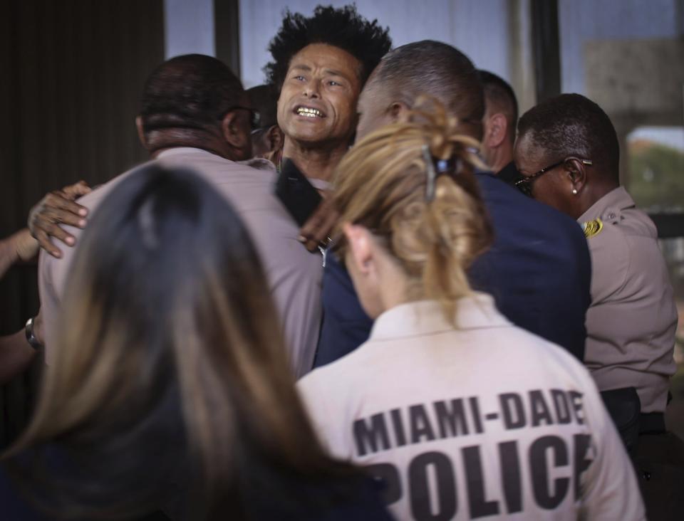 Mourning father Clayton Dillard is ushered away after an outburst at the press conference on May 31. Source: AP