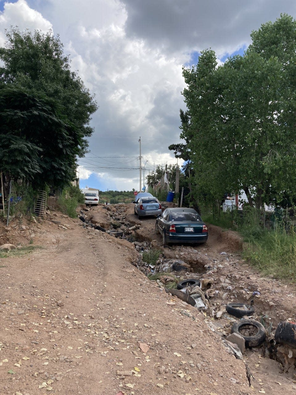 Gashes in the steep streets of Nogales, Sonora dig out trash and tires that neighbors placed to ease down the water currents. Each rain season carves out new streams, destroying the dirt streets of the border city.